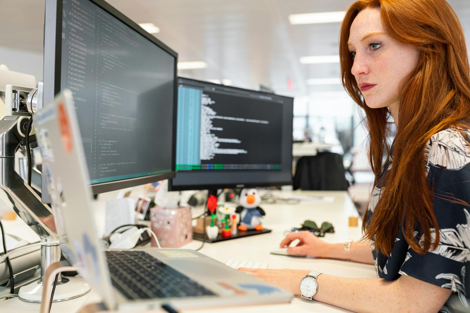 Photo by ThisIsEngineering A focused female software engineer coding on dual monitors in a modern office.