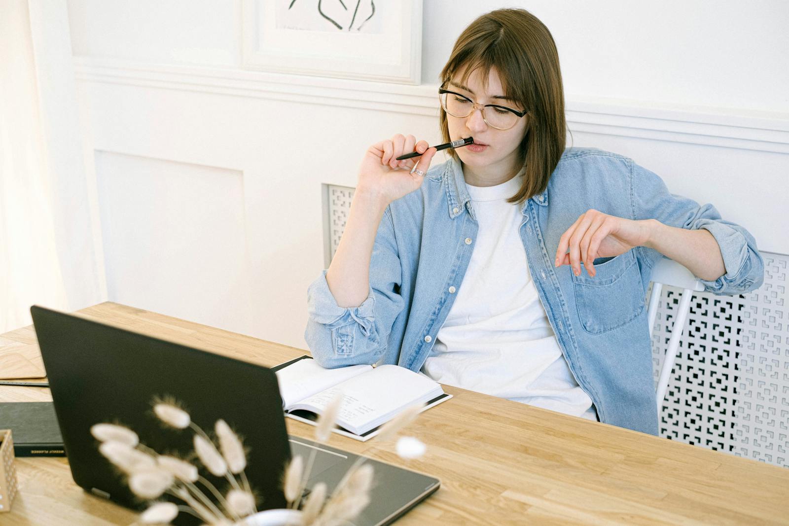 Photo by Ivan Samkov Woman working thoughtfully in home office, reflecting on ideas with laptop and notebook.
