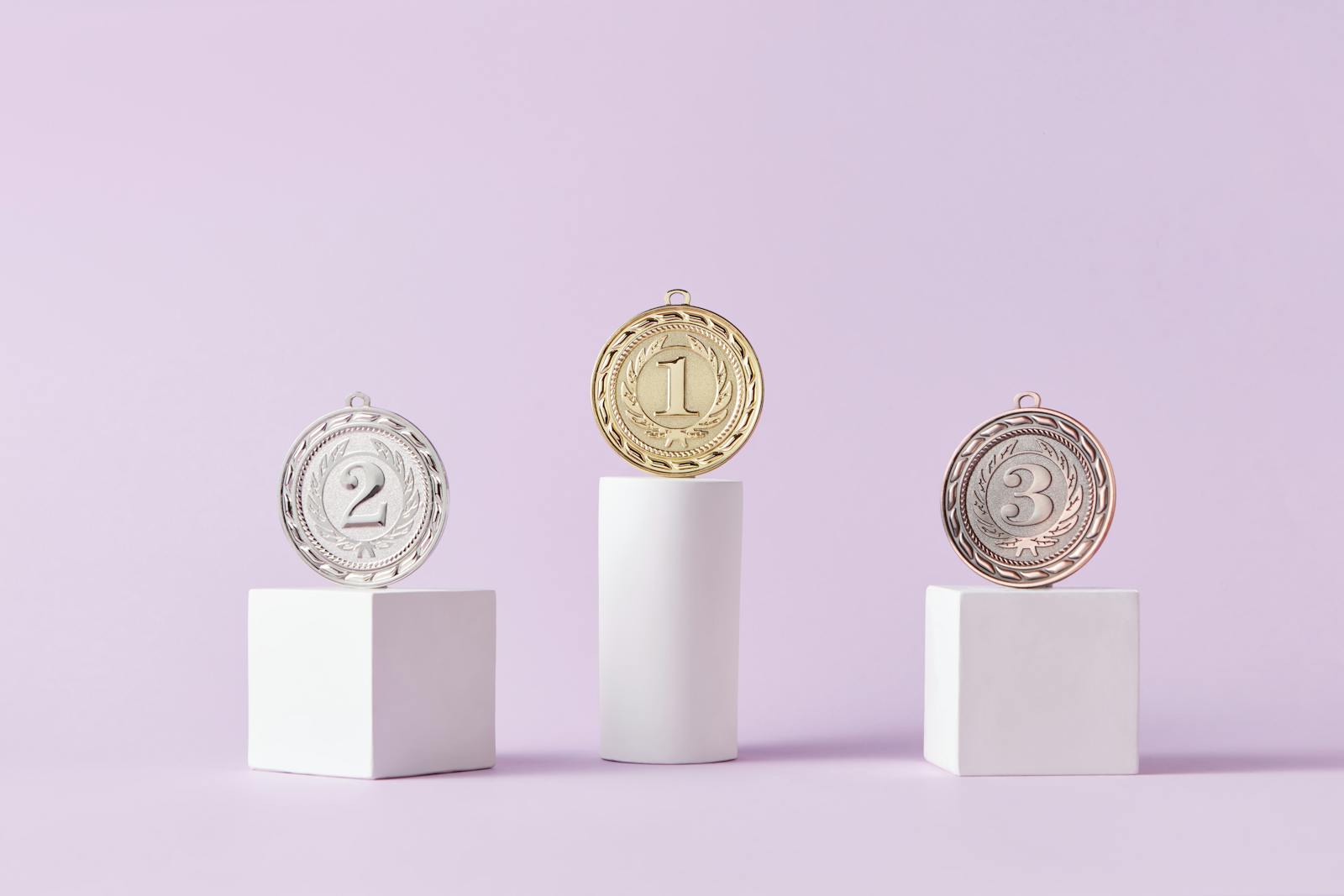 Photo by DS stories Medals on a podium against a soft pastel background, ideal for awards themes.